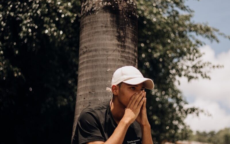 a man sitting on a blue bench next to a tree
