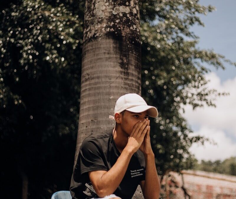 a man sitting on a blue bench next to a tree
