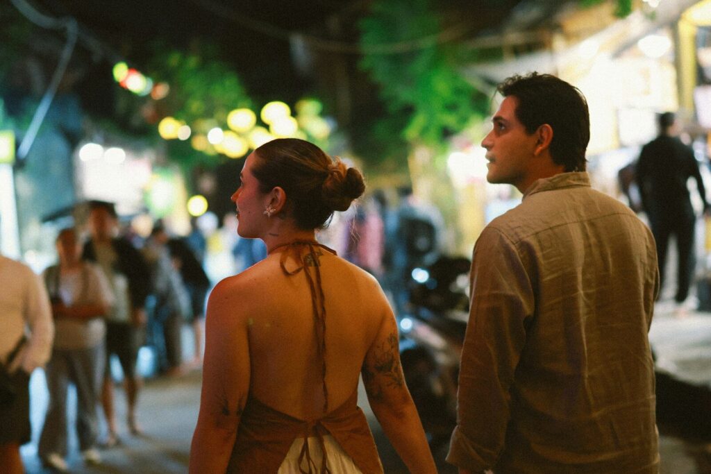 Couple walking down a busy street at night