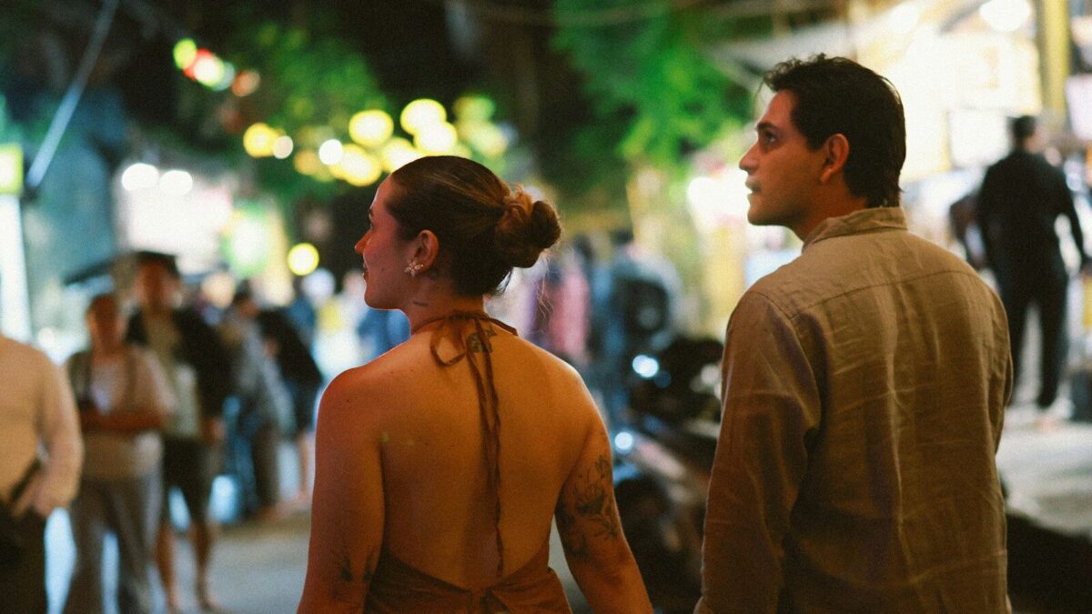 Couple walking down a busy street at night