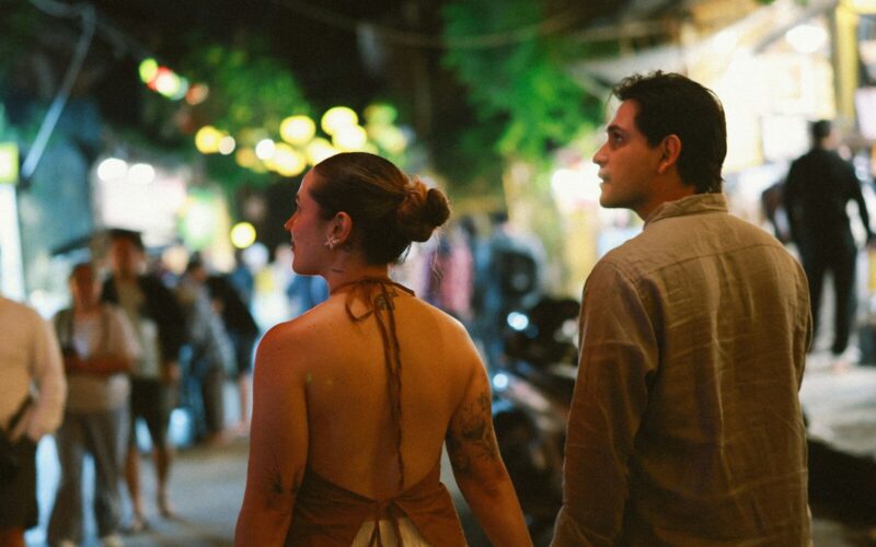 Couple walking down a busy street at night