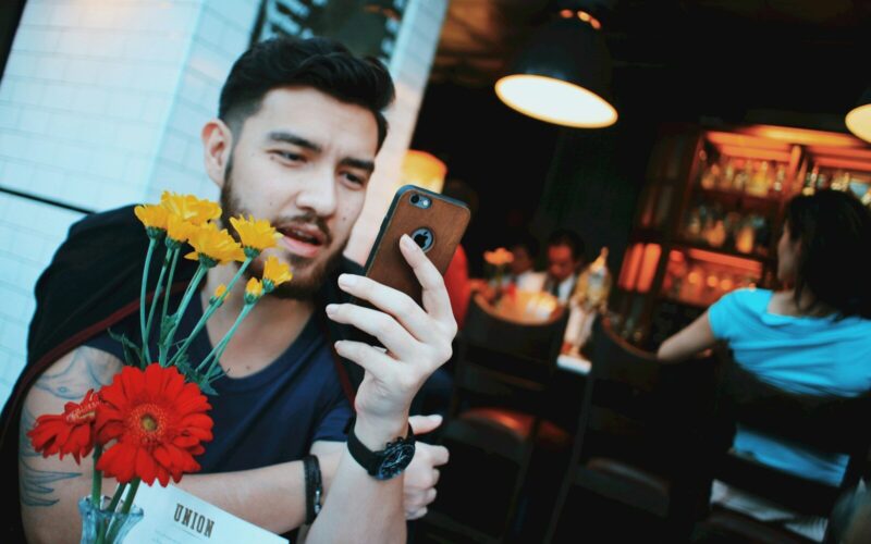man in black tank top holding gold iphone 6