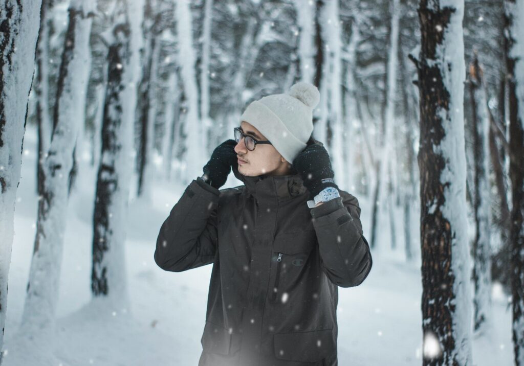a woman standing in the snow in front of trees
