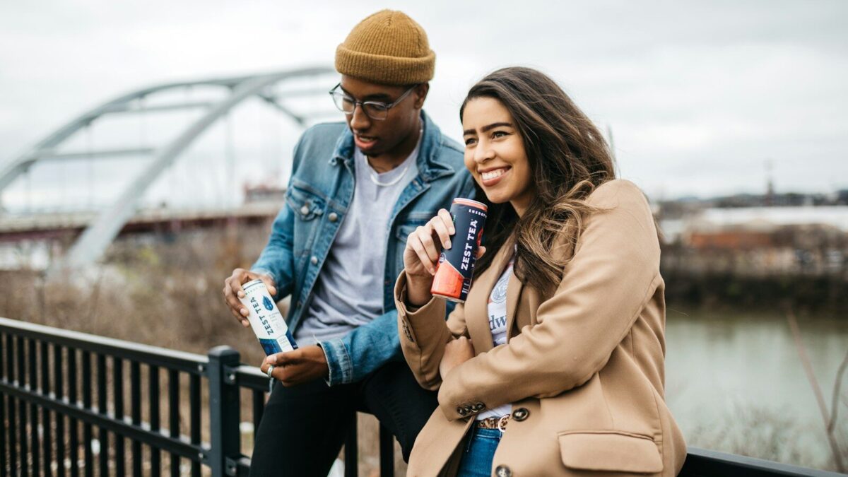 woman in brown coat holding white and blue labeled bottle