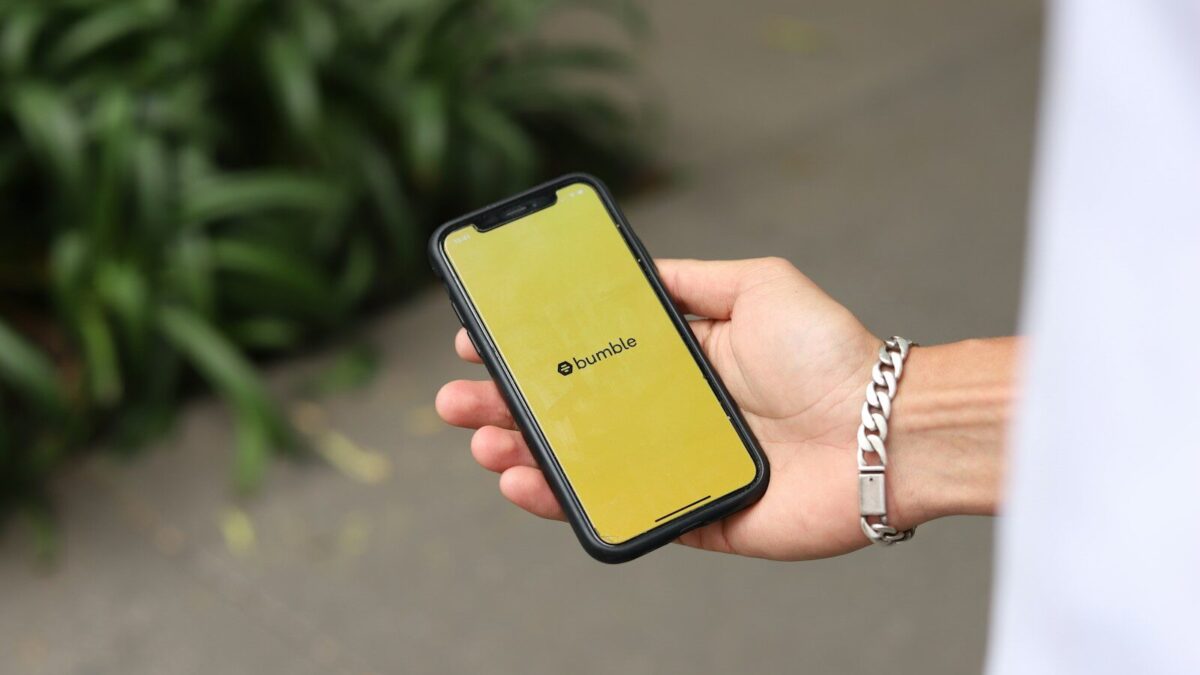 a person holding a yellow cell phone in their hand