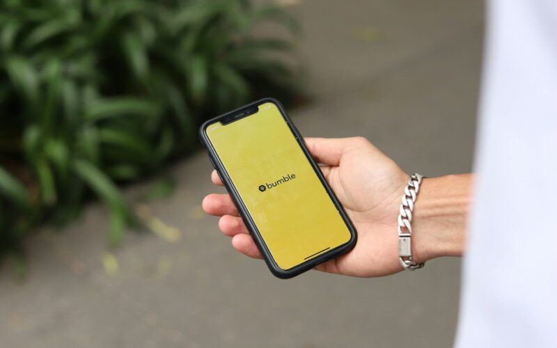 a person holding a yellow cell phone in their hand