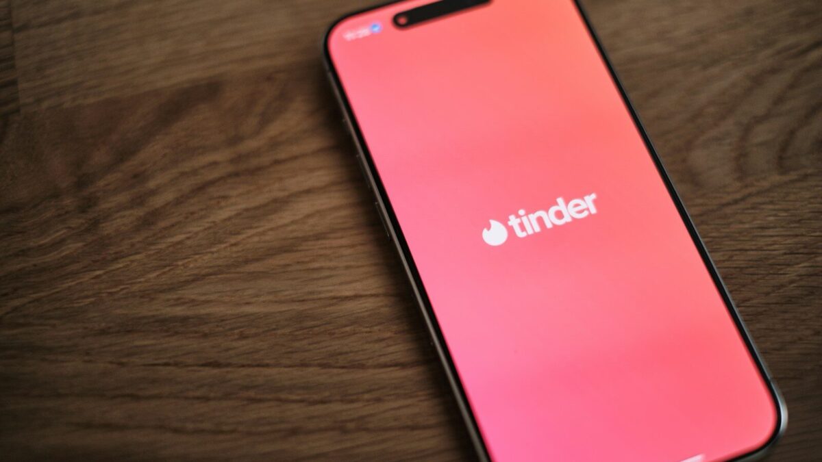 A pink iPhone sitting on top of a wooden table