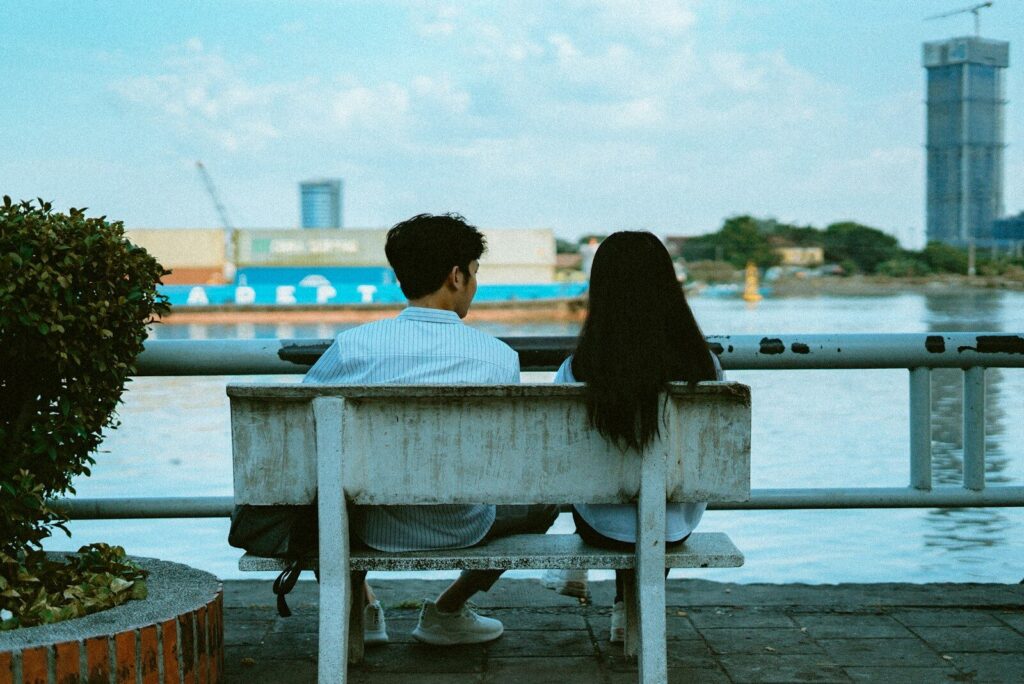 man and woman sitting on bench during daytime