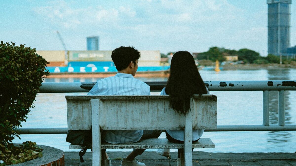 man and woman sitting on bench during daytime