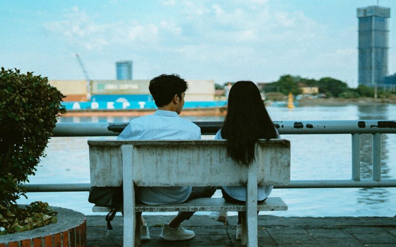 man and woman sitting on bench during daytime