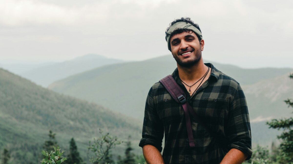 a man standing in front of a forest