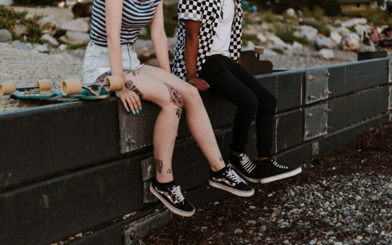 two person sits on fence