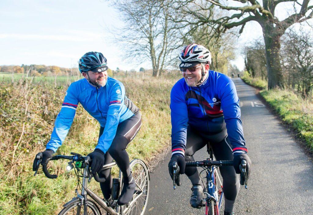 a couple of men riding bikes down a road