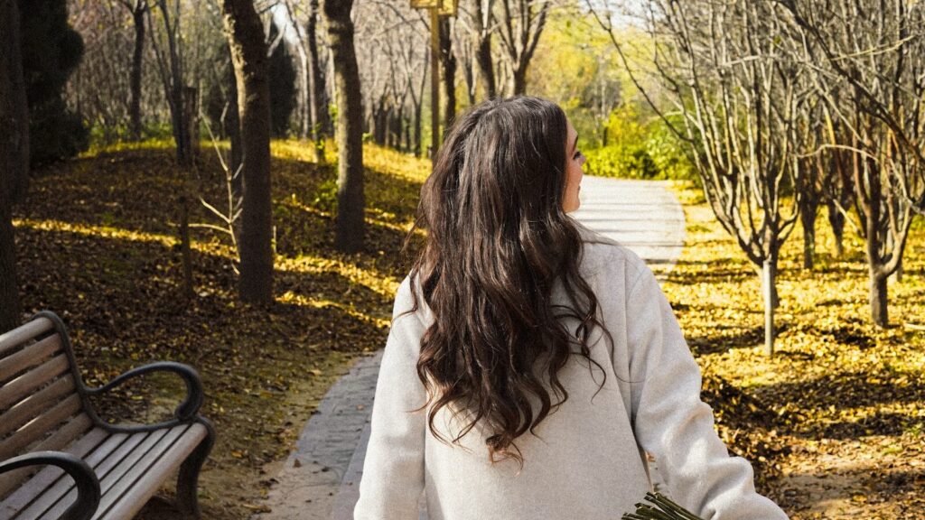 Woman walking on a path in autumn park