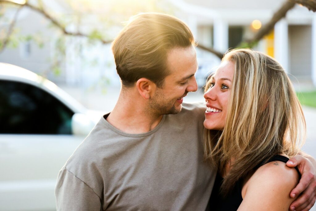 man in gray crew neck shirt kissing woman in black tank top