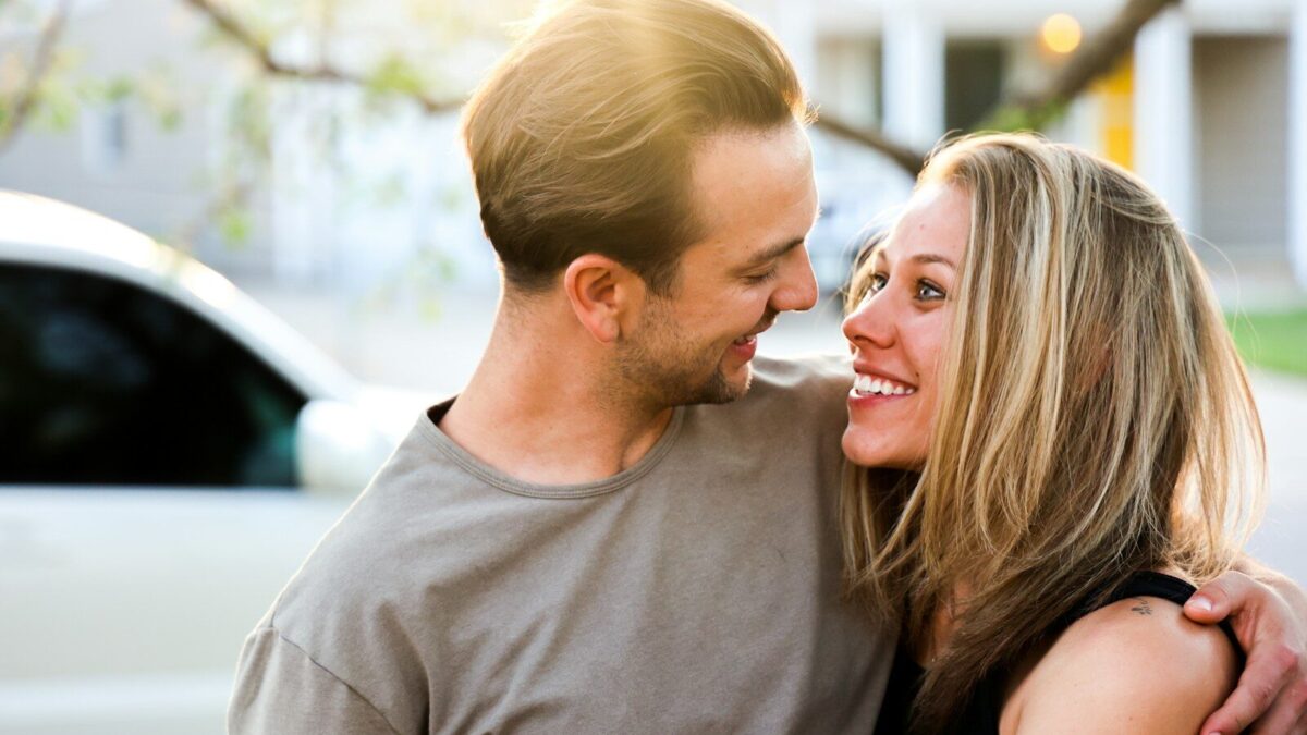 man in gray crew neck shirt kissing woman in black tank top