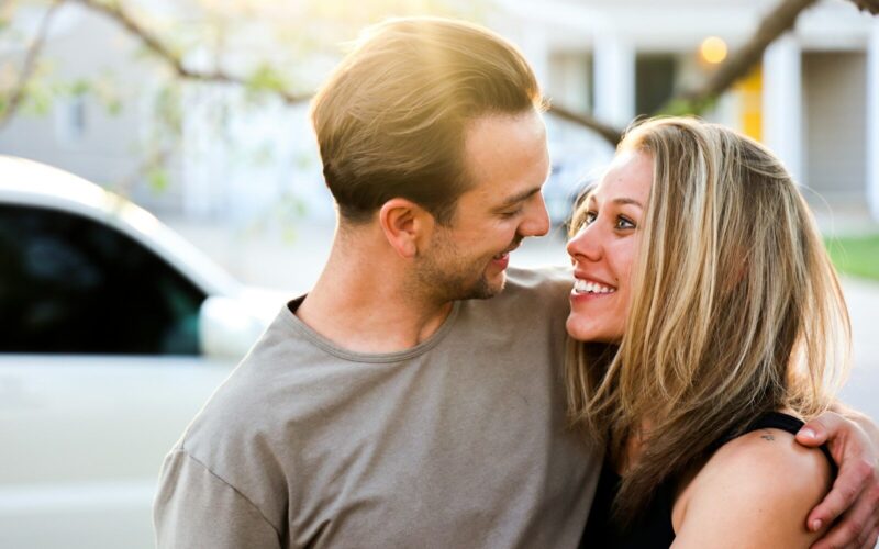 man in gray crew neck shirt kissing woman in black tank top