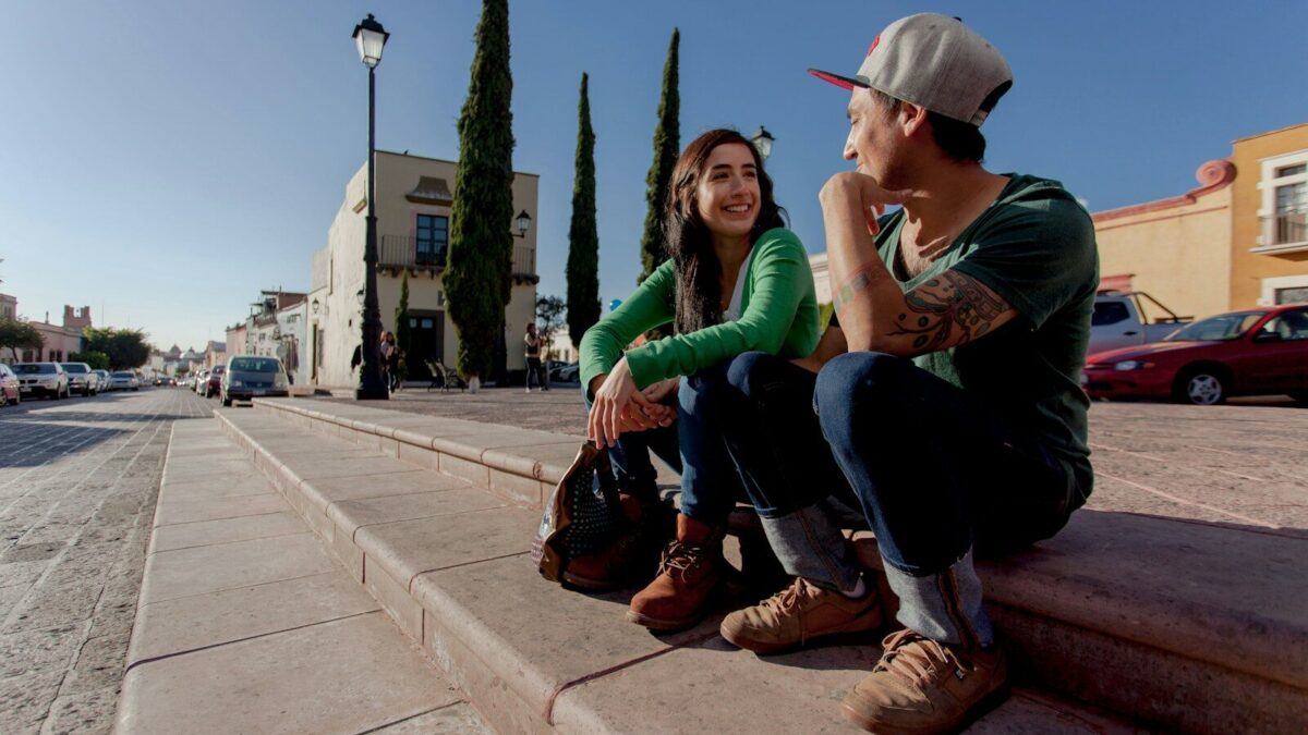 man and woman sitting on concrete bench during daytime