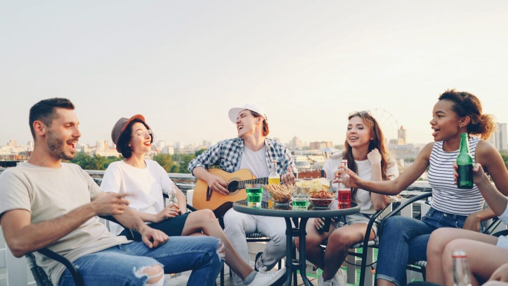 Friends enjoying a rooftop party with music and drinks