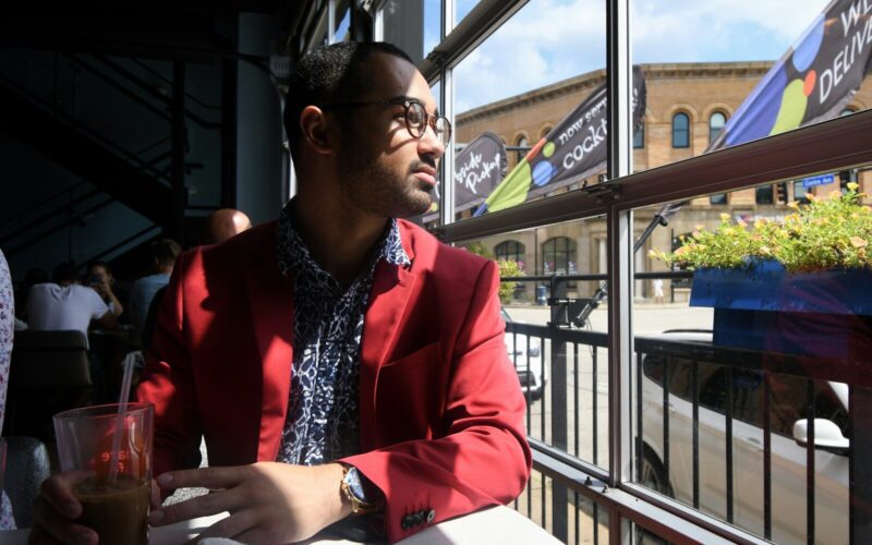 woman in red blazer sitting by the window