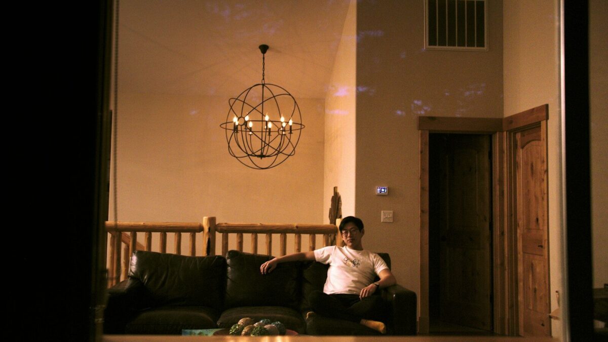 man in white dress shirt sitting on black couch