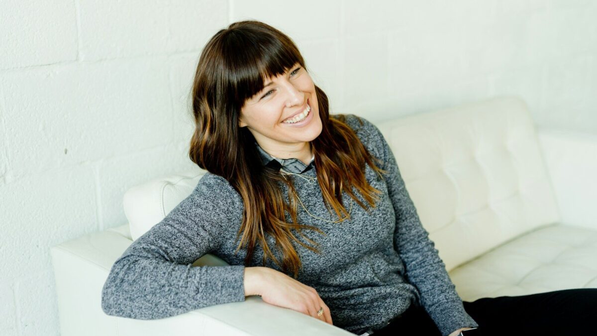woman in gray sweater sitting on white chair